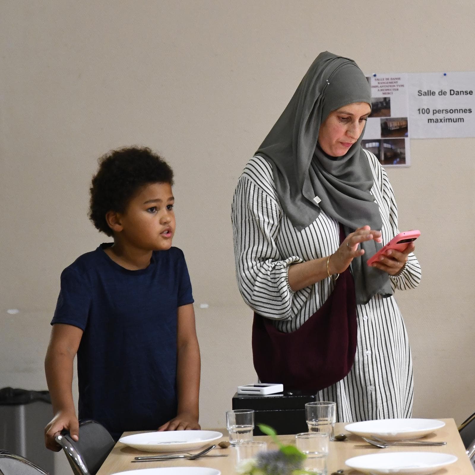 Une participante et un enfant près des tables du dîner
