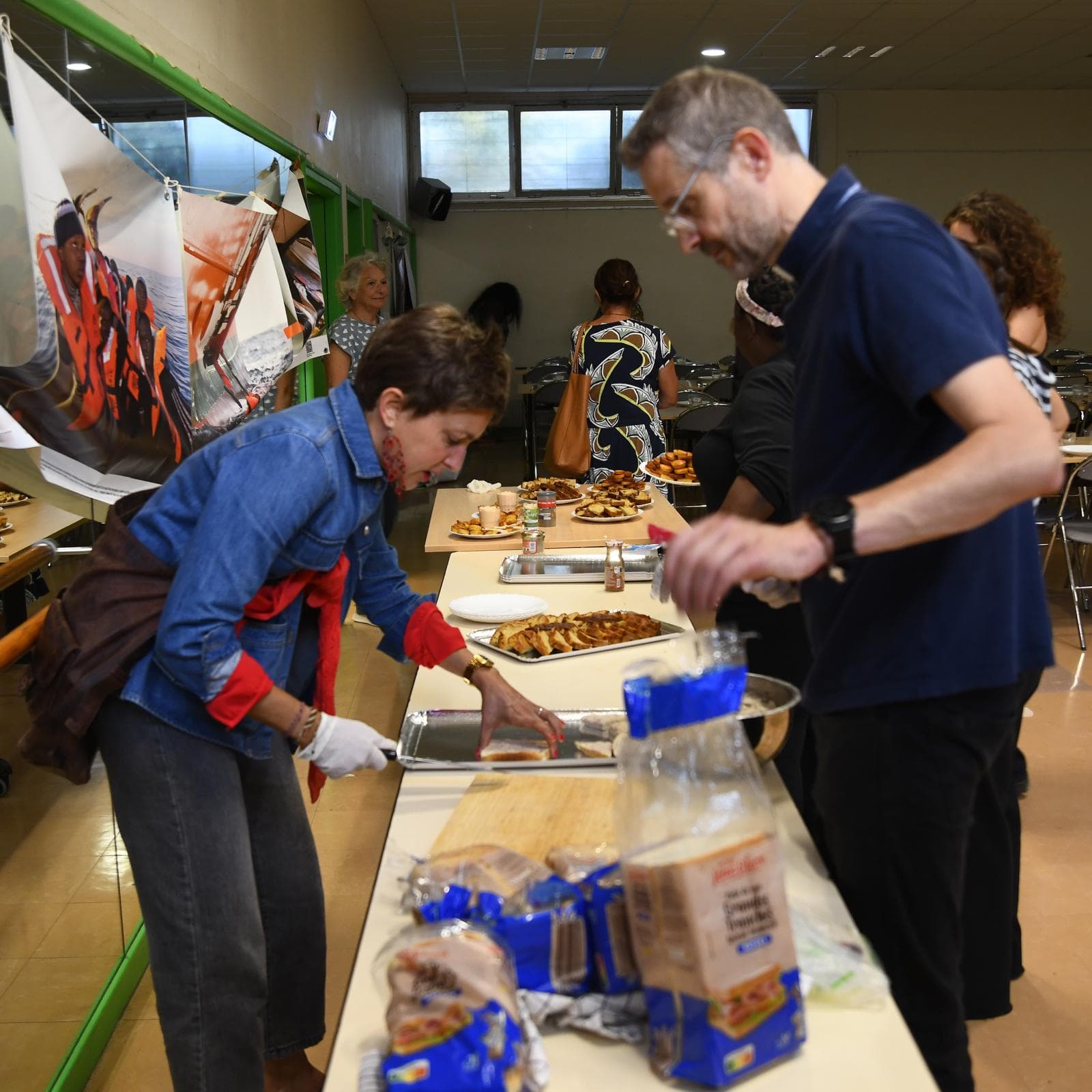 Bénévoles à l'œuvre autour de la table du buffet