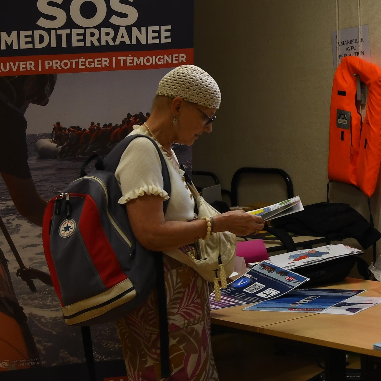 Une visiteuse parcourt la documentation du stand de SOS Méditerranée