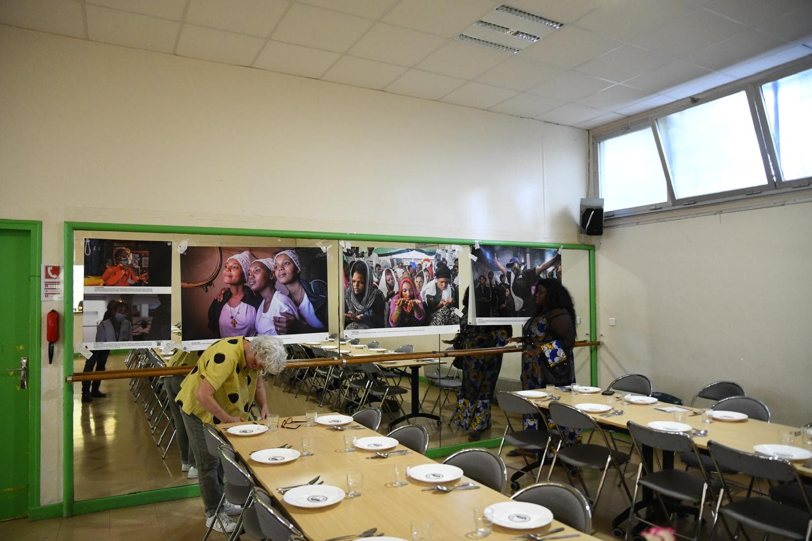 Les tables dressées pour le dîner, devant les photographies de l'exposition accrochées au mur